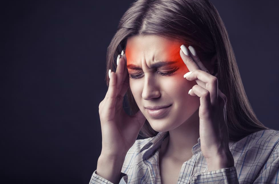 GIRL HOLDING HER HEAD DUE TO MIGRAINE